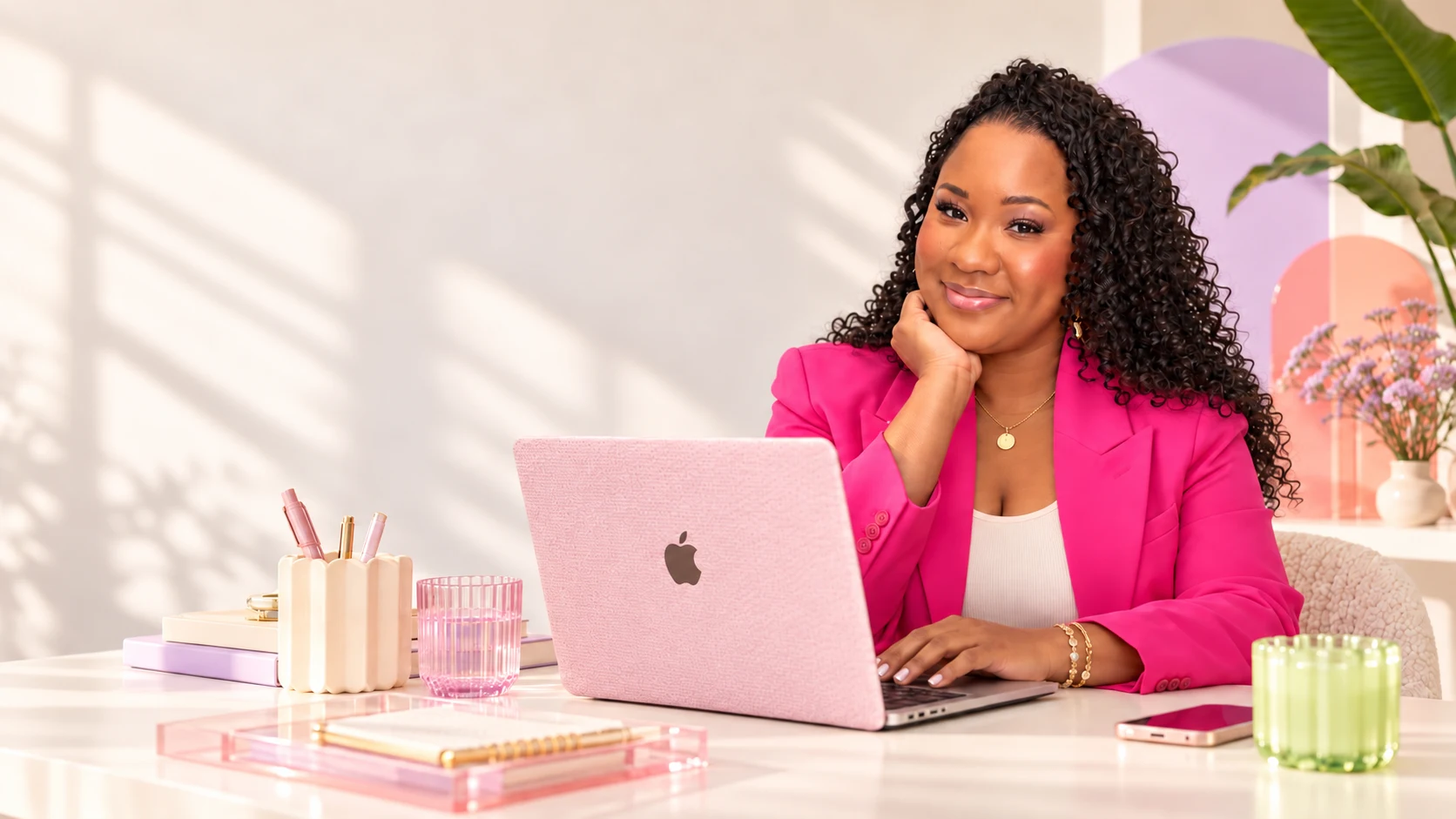 Nichellee Marsh working at a pink laptop in her creative studio
